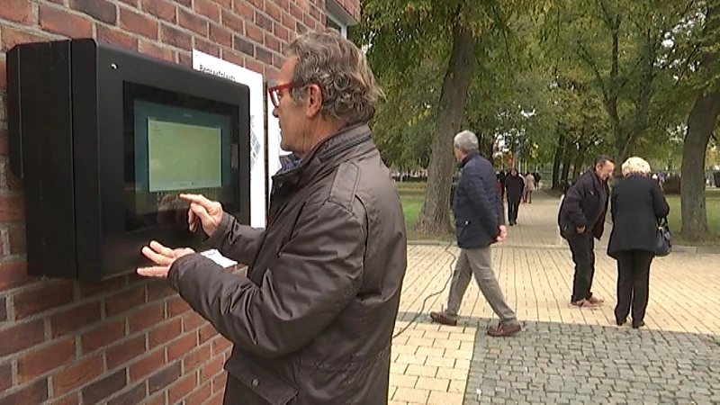 Digitaal scherm wijst Truienaren de weg op het kerkhof