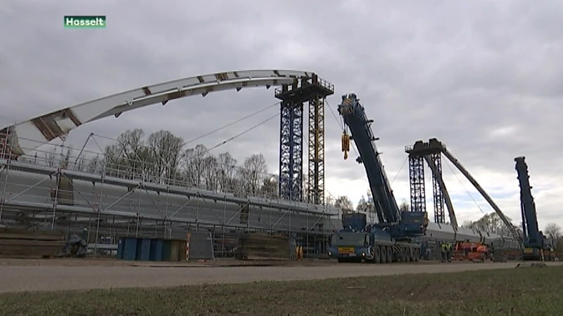 Laatste onderdeel van de brug van Stokrooie wordt gemonteerd. Heel wat kijklustigen kijken toe.