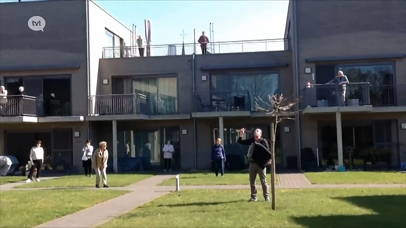 Accordeonspeler geeft balkonconcert voor senioren van Amideus in Berkenbos