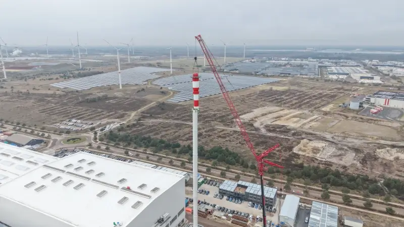 Indrukwekkende beelden: laatste deel van 102 meter hoge schoorsteen geplaatst van Lommelse glasfabriek