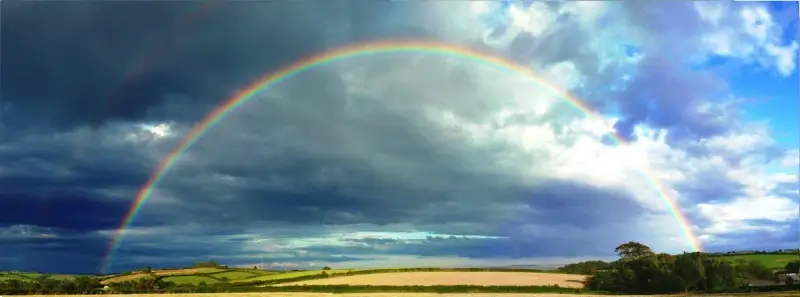 Fietsen door regenbogen onder kruispunt van Universiteitslaan in Hasselt